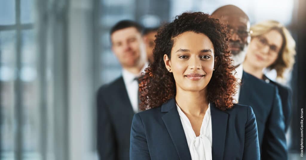 business woman standing with team behind her