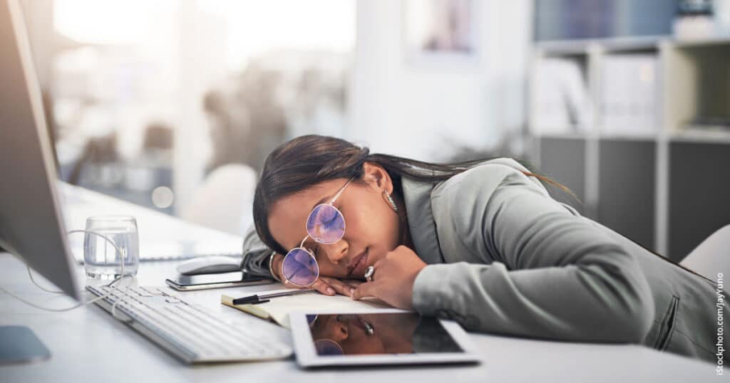tired businesswoman asleep at her desk