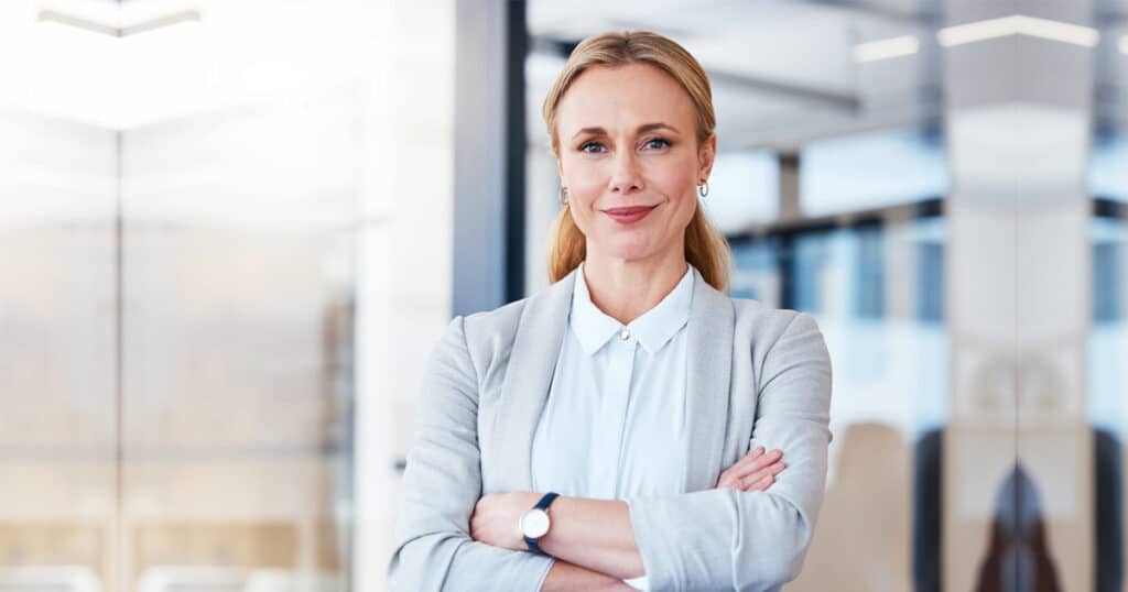 confident and mature businesswoman standing with arms folded