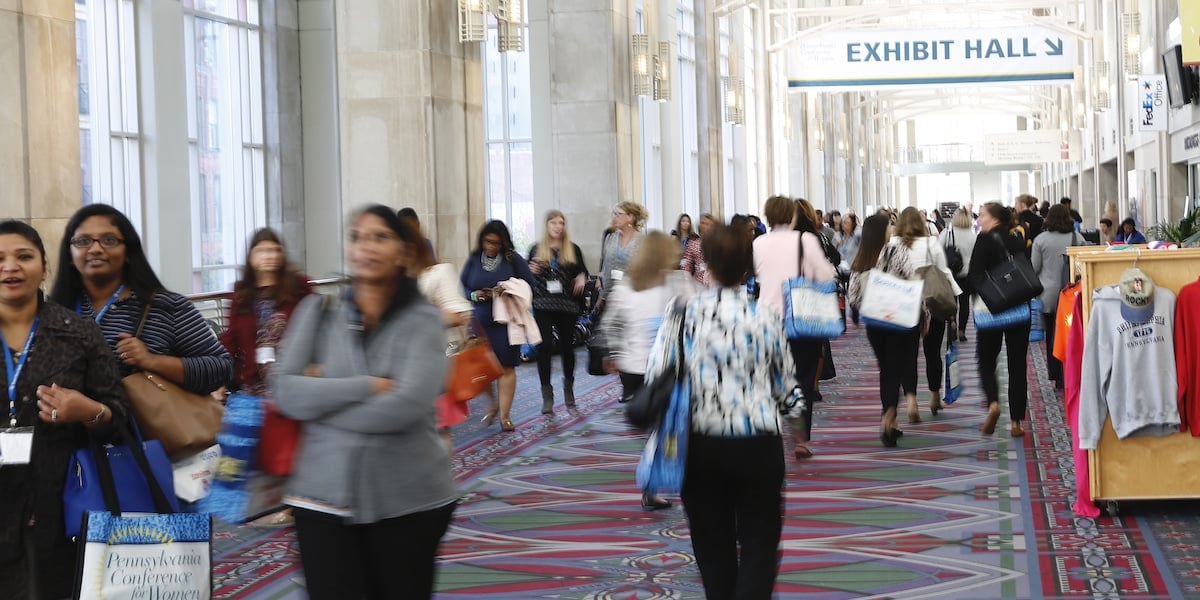 Women at the PA Conference for Women walking towards a sign for the Exhibit Hall.