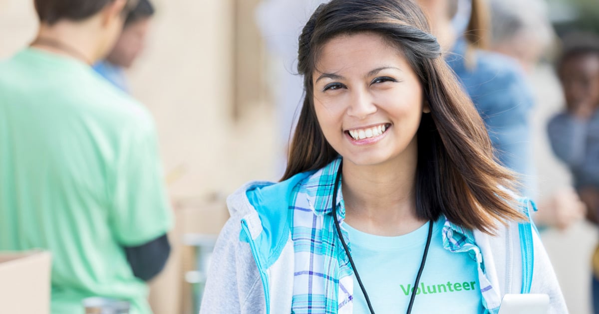 cheerful Filipino woman managing outdoor food and clothing drive during community charity event