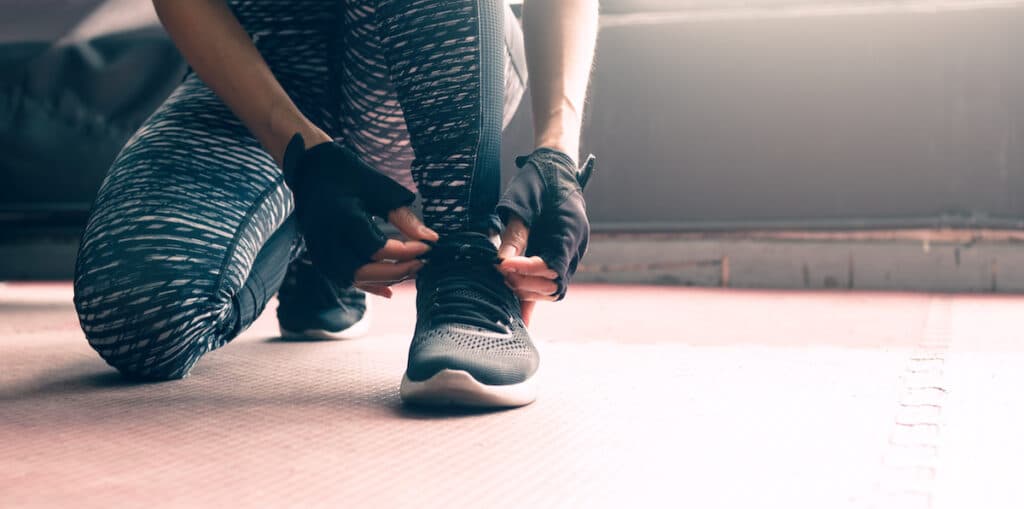 Close up woman lacing up sneakers