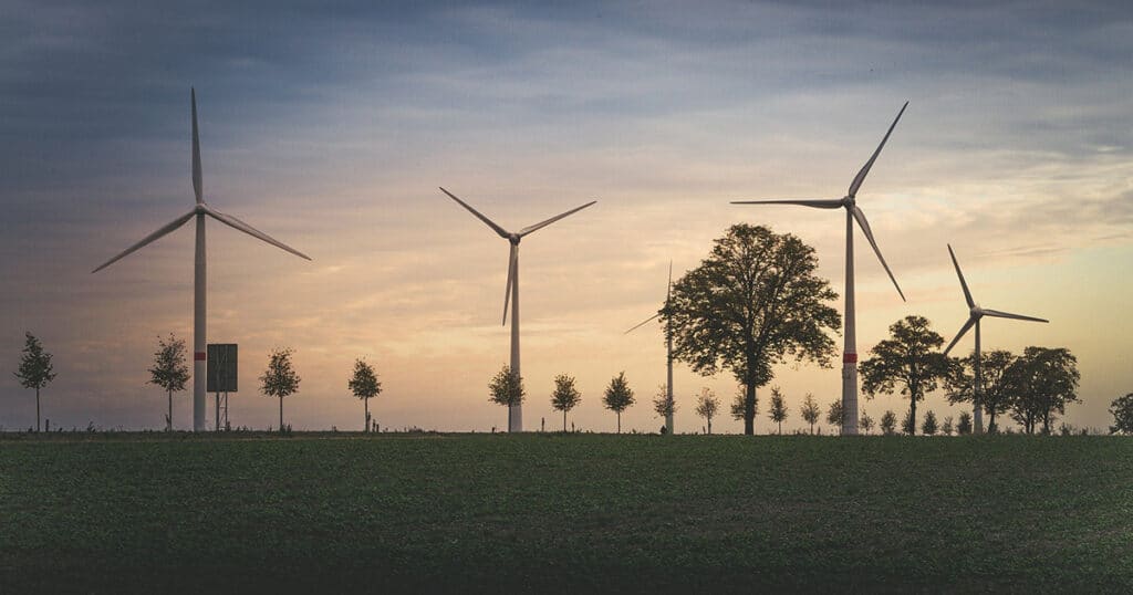 Windmills and trees on an open green plain