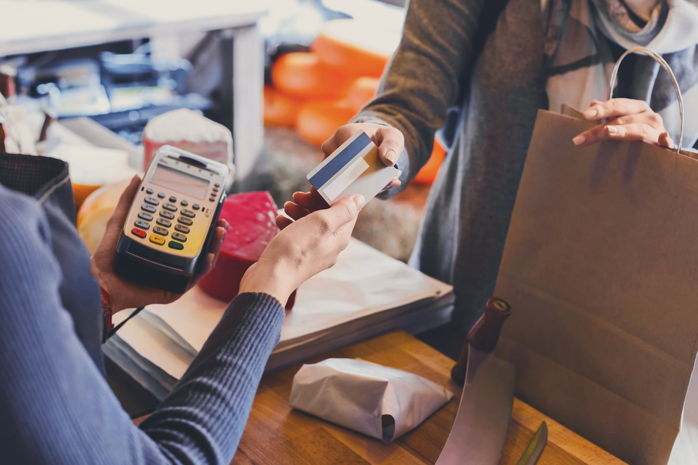 Customer paying for order of cheese in grocery shop.